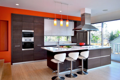 Inspiration for a contemporary open concept kitchen remodel in DC Metro with an undermount sink, flat-panel cabinets, dark wood cabinets, quartz countertops, white backsplash, stone slab backsplash and paneled appliances