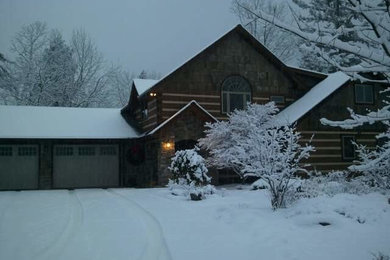 Large mountain style brown two-story wood exterior home photo in Other with a shingle roof
