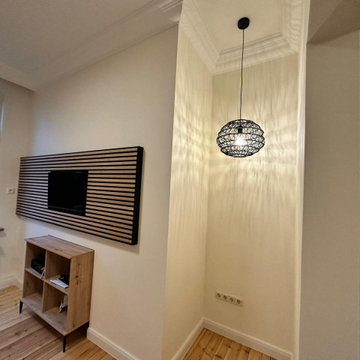 Renoviertes Altbau-Wohnzimmer mit Akustikpaneelen und Holzdielen