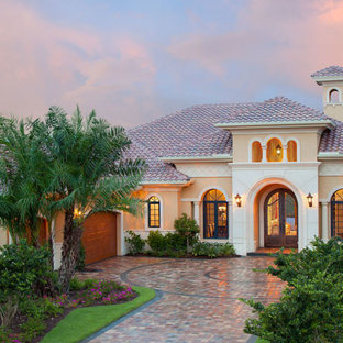 На фото: большая входная дверь в средиземноморском стиле с двустворчатой входной дверью и металлической входной дверью с