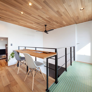 Idéer för att renovera ett litet industriellt arbetsrum, med vita väggar, en öppen vedspis, brunt golv, mellanmörkt trägolv och ett inbyggt skrivbord