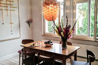 Geschlossenes, Kleines Mid-Century Esszimmer ohne Kamin mit weißer Wandfarbe, braunem Holzboden und braunem Boden in Sonstige
