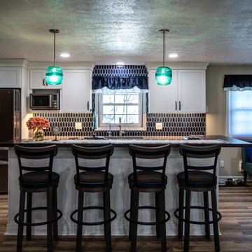 White Kitchen with Blue Tiled Backsplash and Two Tier Island