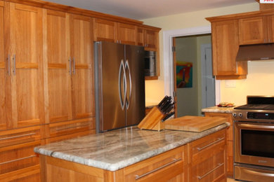 Enclosed kitchen - large traditional u-shaped enclosed kitchen idea in Toronto with an undermount sink, shaker cabinets, medium tone wood cabinets, granite countertops, stainless steel appliances and an island