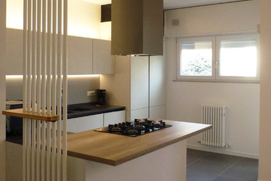 Esempio di una cucina contemporanea di medie dimensioni con lavello sottopiano, ante lisce, ante bianche, top in quarzite, paraspruzzi grigio, elettrodomestici in acciaio inossidabile, pavimento in gres porcellanato, pavimento grigio e top grigio