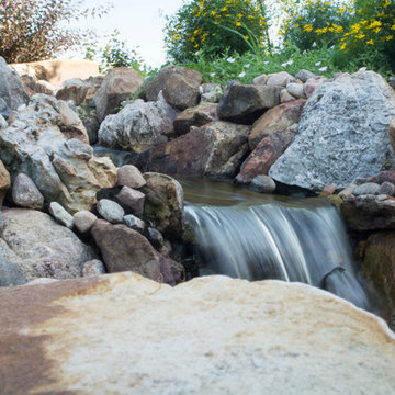 Rustic Mountain stream flowing into lakeside patio
