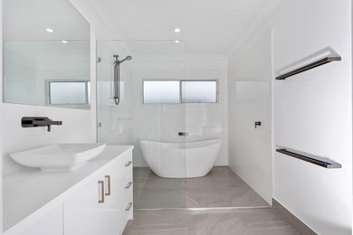 Design ideas for a small contemporary kids bathroom in Brisbane with white cabinets, a freestanding tub, an open shower, a one-piece toilet, white tile, ceramic tile, white walls, ceramic floors, a vessel sink, grey floor, an open shower and white benchtops.