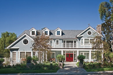 This is an example of a large traditional three-storey grey house exterior in Orange County with wood siding, a hip roof and a shingle roof.