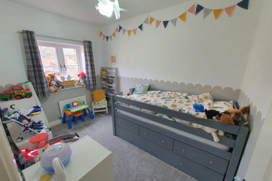 Diseño de habitación de bebé niño minimalista pequeña con paredes blancas, moqueta y suelo gris