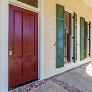 Пример оригинального дизайна интерьера: одноэтажный фасад дома среднего размера желтого цвета в классическом стиле с комбинированной облицовкой и вальмовой крышей