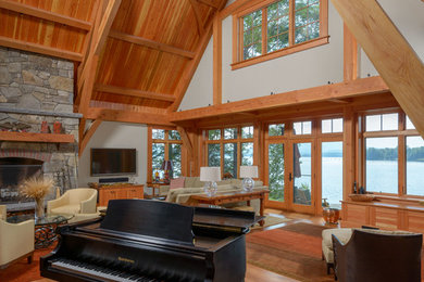 Inspiration for a large timeless open concept medium tone wood floor and brown floor living room remodel in Boston with a music area, gray walls, a standard fireplace, a stone fireplace and no tv