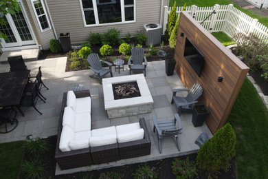 Photo of a large contemporary back patio in Chicago with a fire feature, natural stone paving and no cover.