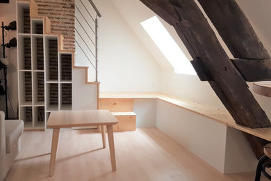 Imagen de sala de estar tipo loft clásica pequeña sin chimenea con paredes blancas, suelo de madera clara, suelo marrón, vigas vistas y ladrillo
