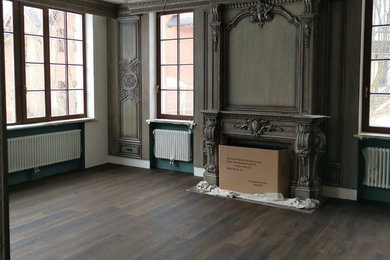Inspiration pour un grand salon traditionnel ouvert avec un mur vert, parquet foncé, une cheminée standard, un manteau de cheminée en bois et un sol marron.