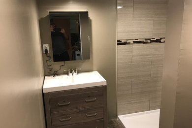 Small minimalist ceramic tile and gray floor basement photo in New York with beige walls