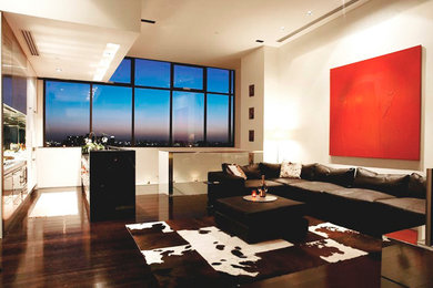 Diseño de salón para visitas abierto actual de tamaño medio con paredes blancas, suelo de madera pintada, televisor independiente y suelo negro