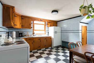 Eat-in kitchen - mid-sized mid-century modern l-shaped linoleum floor eat-in kitchen idea with light wood cabinets, blue backsplash, ceramic backsplash, white appliances and no island