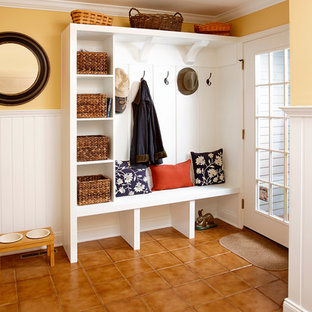 ニューヨークの中サイズの片開きドアトランジショナルスタイルのおしゃれなマッドルーム (黄色い壁、セラミックタイルの床、ガラスドア) の写真