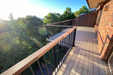 Design ideas for a large modern backyard and first floor deck in Sydney with no cover and metal railing.