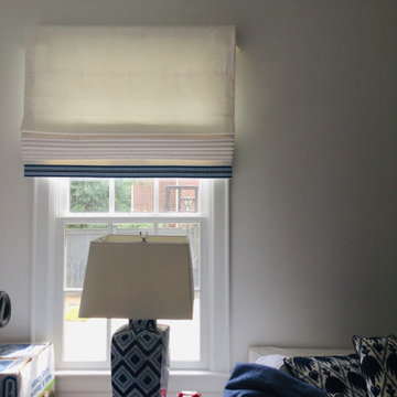 Cordless functional Roman shades with blue tape on the bottom.