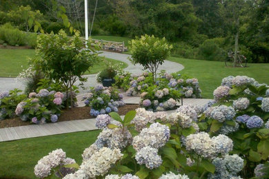 Photo of a mid-sized traditional full sun backyard stone retaining wall landscape in Boston.