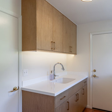 The laundry room has a new sink and cabinetry that follows the style found in th