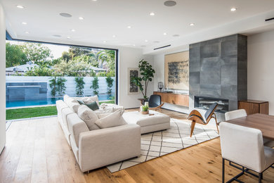Inspiration for a large contemporary formal and open concept light wood floor and beige floor living room remodel in Los Angeles with white walls, a standard fireplace, a stone fireplace and no tv