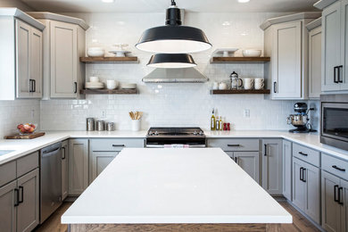 Design ideas for a mid-sized traditional u-shaped eat-in kitchen in Chicago with an undermount sink, shaker cabinets, grey cabinets, quartz benchtops, white splashback, subway tile splashback, stainless steel appliances, light hardwood floors, with island, beige floor and white benchtop.