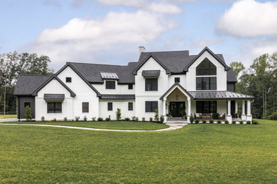 Inspiration for a farmhouse white two-story mixed siding and board and batten exterior home remodel in Other with a mixed material roof and a black roof