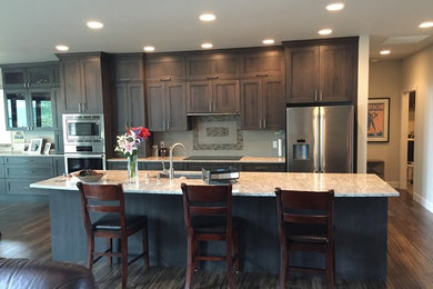 Mid-sized trendy galley dark wood floor open concept kitchen photo in Seattle with an undermount sink, shaker cabinets, dark wood cabinets, beige backsplash, mosaic tile backsplash, stainless steel appliances, an island and granite countertops