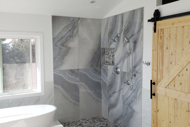 Imagen de cuarto de baño principal minimalista grande con bañera exenta, ducha abierta, baldosas y/o azulejos grises, paredes grises, suelo de mármol, suelo beige, ducha abierta y bandeja