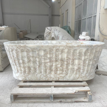 Sculptural Calacatta Gold Marble Bathroom with Hand-Carved Bathtub