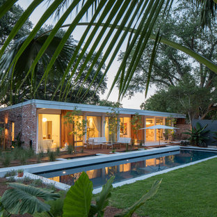 Retro Pool hinter dem Haus in rechteckiger Form mit Natursteinplatten in New Orleans