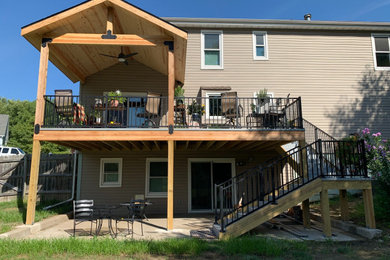 Deck - large contemporary backyard second story metal railing deck idea in Kansas City with a roof extension