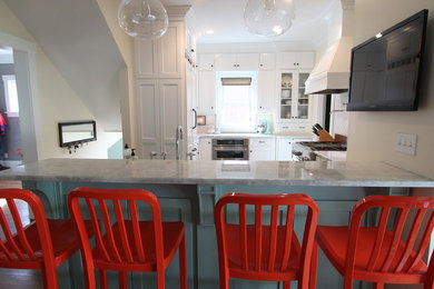 Inspiration for a mid-sized transitional medium tone wood floor eat-in kitchen remodel in Omaha with a farmhouse sink, shaker cabinets, white cabinets, quartzite countertops, white backsplash, ceramic backsplash, paneled appliances and a peninsula