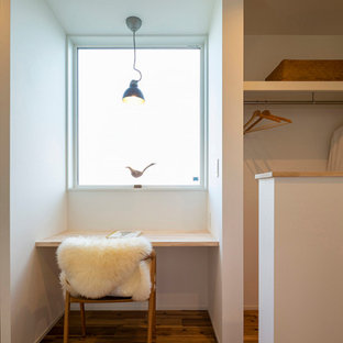 Mittelgroßes Nordisches Arbeitszimmer ohne Kamin mit Arbeitsplatz, weißer Wandfarbe, braunem Holzboden, Einbau-Schreibtisch, braunem Boden, Tapetendecke und Tapetenwänden in Sonstige