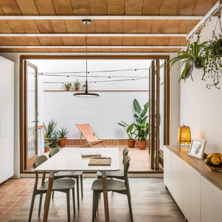 Ejemplo de cocina lineal, mediterránea, pequeña, abierta, sin isla, con armarios con paneles lisos, puertas de armario blancas, salpicadero blanco, salpicadero de azulejos de cerámica, electrodomésticos blancos, suelo de baldosas de terracota, suelo marrón y encimeras blancas
