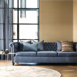 Modern inredning av ett vardagsrum, med gula väggar och mellanmörkt trägolv