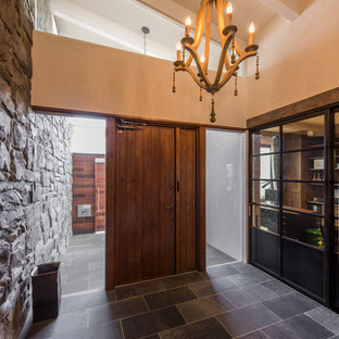 横浜の引き戸おしゃれな玄関ホール (マルチカラーの壁、木目調のドア、グレーの床) の写真