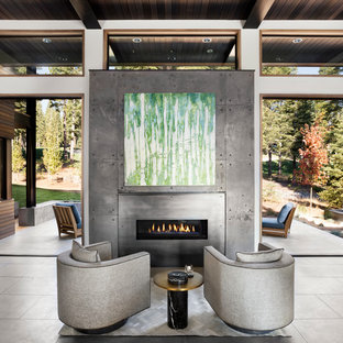 Modern inredning av ett stort allrum med öppen planlösning, med en hemmabar, vita väggar, klinkergolv i porslin, en bred öppen spis och en spiselkrans i betong