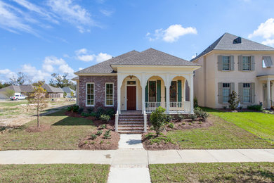 Mid-sized traditional yellow one-story mixed siding exterior home idea in New Orleans with a hip roof