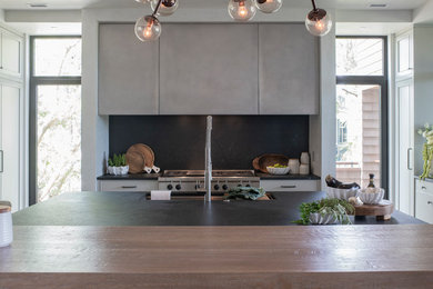 Transitional u-shaped kitchen photo in Charleston with flat-panel cabinets, stainless steel cabinets, wood countertops and an island