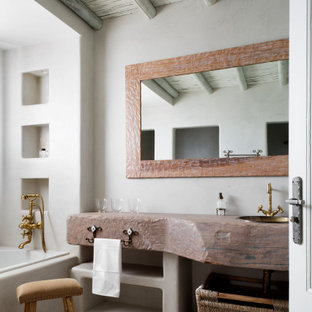 Ejemplo de cuarto de baño hornacina, único, a medida y madera, marinero, con armarios abiertos, puertas de armario grises, bañera empotrada, paredes blancas, suelo de baldosas tipo guijarro, lavabo encastrado, encimera de madera, suelo beige y encimeras marrones