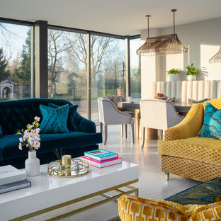 Inredning av ett modernt stort allrum med öppen planlösning, med grå väggar, kalkstensgolv och grått golv