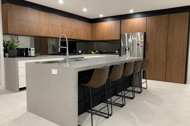 Design ideas for a mid-sized modern galley eat-in kitchen in Sydney with a double-bowl sink, flat-panel cabinets, white cabinets, marble benchtops, black splashback, mirror splashback, black appliances, with island and grey benchtop.