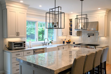 Inspiration for a modern kitchen remodel in Boston with a farmhouse sink, quartzite countertops, white backsplash, stainless steel appliances and an island