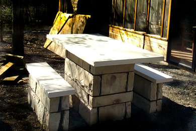 Example of a mountain style backyard stone patio design in Little Rock with a fireplace