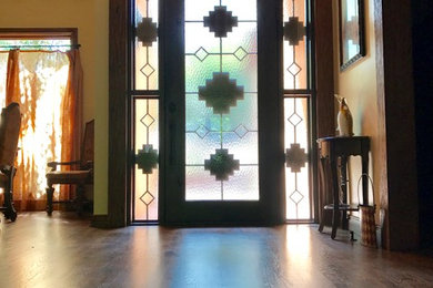 Entryway - mid-sized southwestern dark wood floor and brown floor entryway idea in Oklahoma City with brown walls and a dark wood front door