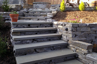 Inspiration for a rustic partial sun backyard stone retaining wall landscape in Seattle.