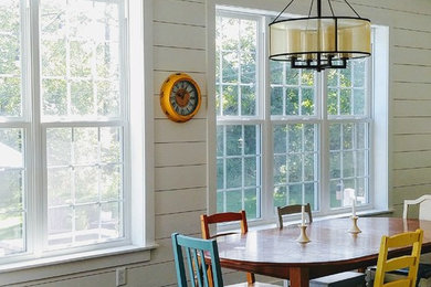 This is an example of a mid-sized country open plan dining in Other with white walls, dark hardwood floors, no fireplace and black floor.